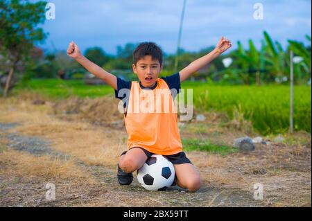 Lifestyle-Porträt von schönen und glücklichen jungen halten Fußball spielen Fußball im Freien auf grünen Wiese lächelnd fröhlich in Training ves Stockfoto