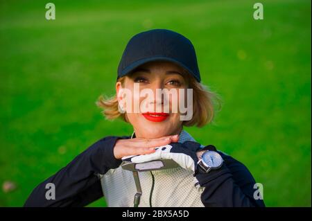 Lifestyle im Freien Porträt der jungen schönen und glücklichen Frau am Golf spielen lehnend süß auf Club lächelnd fröhlich in stilvollen Golfkleidung isola Stockfoto