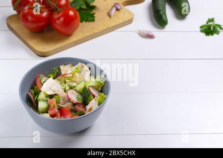 Fattoush Salat in einer grauen Schüssel mit Zutaten auf weißem Hintergrund. Speicherplatz kopieren. Levantine fattoush Brotsalat, der aus getrockneten Pita br Stockfoto