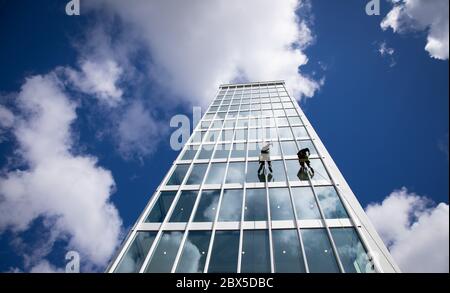 Hamburg, Deutschland. Juni 2020. Industriekletterer sabbern die Glasfassade des neuen "Springer Quartier" herunter und reinigen die Fenster. Das denkmalgeschützte 14-stöckige Hochhaus am Axel-Springer-Platz wurde saniert und um einen neuen Gebäudekomplex erweitert. Zu den zukünftigen Nutzern zählen unter anderem die Axel Springer SE und KPMG. Kredit: Christian Charisius/dpa/Alamy Live News Stockfoto