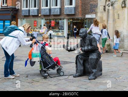 Lebende Statue Street Performer mit einer Sammlung Glas in einem Einkaufszentrum in Chichester, West Sussex, England, UK. Stockfoto