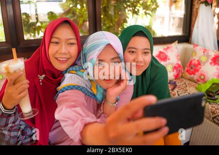 Muslimische Teenager Schüler Freundinnen Selfie. Glücklich und hübsch asiatisch indonesische Mädchen in traditionellen islamischen Hijab Kopf Schal unter Selfie zusammen hav Stockfoto