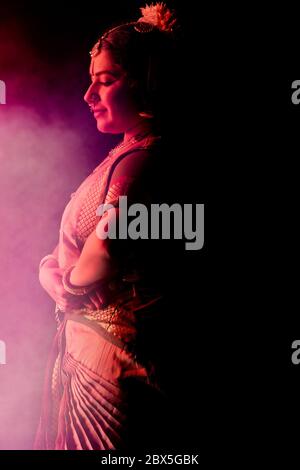 Bharatnatyam Tänzerin anmutig vor einem dunklen Hintergrund stehend. Stockfoto