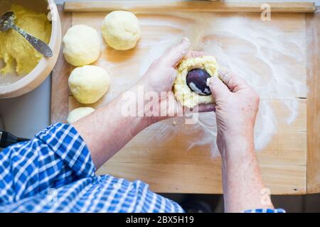 Man Hände machen köstliche Pflaumenknödel aus Teig, Food-Konzept Stockfoto