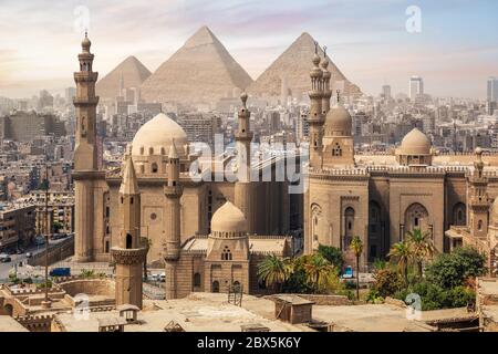 Die Moschee von Sultan Hassan und die Großen Pyramiden von Gizeh, Skyline von Kairo, Ägypten Stockfoto