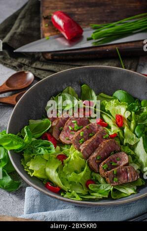 Leckeres Rindfleisch Steak mit Salat, Kräutern und Chili Stockfoto