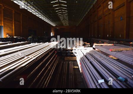 Rundstab aus Stahl in Bündeln, Stapel in einem Lager mit einem Kran. Stockfoto