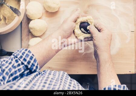 Man Hände machen köstliche Pflaumenknödel aus Teig, Food-Konzept Stockfoto