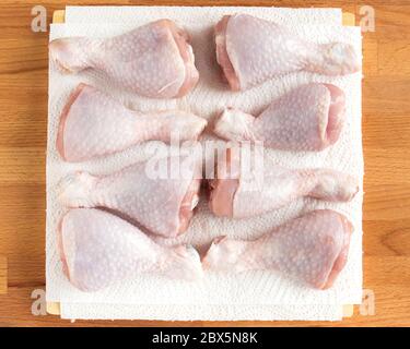 Hühnertrommelstab liegt auf Küchentücher. Hähnchen zum Braten vorbereiten. Stockfoto
