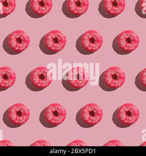 Rosa Donut mit Streuseln nahtloses Muster, süß glasiert Dessert Lebensmittel auf rosa minimal Hintergrund, Draufsicht Stockfoto