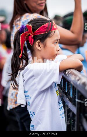 Ein wunderschönes philippinisches Mädchen sieht sich die religiöse Parade und die Feierlichkeiten beim Black Nazarene Festival in Manila, Philippinen, an. Stockfoto