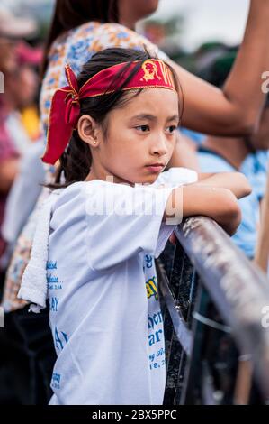 Ein wunderschönes philippinisches Mädchen sieht sich die religiöse Parade und die Feierlichkeiten beim Black Nazarene Festival in Manila, Philippinen, an. Stockfoto