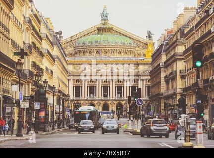Paris, Frankreich - 6. Mai 2019 : Vorderansicht der Alten Garnier Oper in Paris mit Menschen und Autos auf der belebten Straße Stockfoto