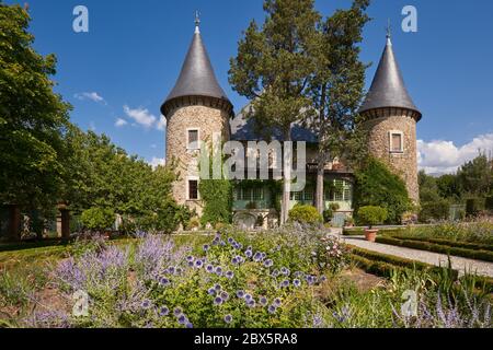 Les Crots, Hautes-Alpes, Frankreich: Schloss Picomtal (historisches Denkmal) mit seinen zwei Türmen und Sommergarten in Blüte. Region Provence-Alpes-Cote d'Azur Stockfoto