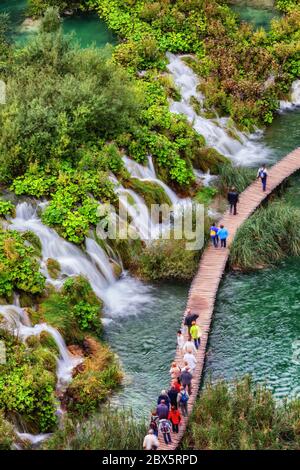 Nationalpark Plitvicer Seen in Kroatien, Menschen, Gruppe von Touristen auf Holzweg über den See mit zahlreichen Wasserfällen, Wasserfälle, Luftwie Stockfoto