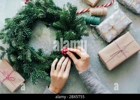 .Weihnachten Tannenkranz aus der oberen Ansicht Hände Geschenke Stockfoto