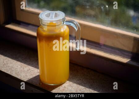 Glaskaraffe mit Kompott aus Sanddorn in der Küche. Selbstgemacht. Geringe Schärfentiefe. Stockfoto