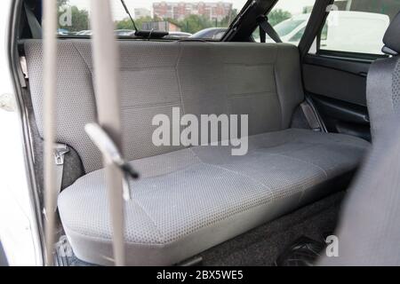 Die hintere Reihe der Passagiersitze in grau gepolstert in einem alten russischen Taxi nach einer Autowäsche und chemische Reinigung im Autoservice. Stockfoto