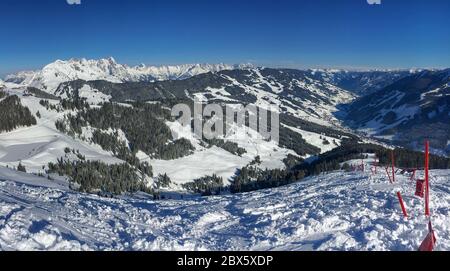 Panoramablick auf die schneebedeckten Berge in der Skiregion Saalbach Hinterglemm in den Österreich alpen vor blauem Himmel Stockfoto