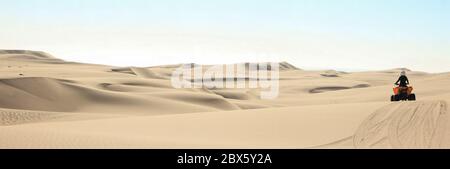 Quad-Fahrende - ein glücklicher Biker in Sandwüstendünen, Afrika, Namibia, Namib, Walvis Bay, Swakopmund. Stockfoto