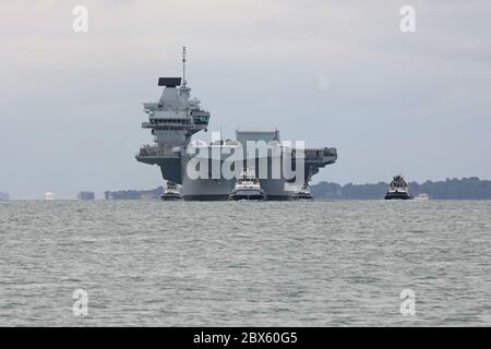 Bogen auf. Schlepper begleiten die Royal Navy Flugzeugträger HMS KÖNIGIN ELIZABETH bei seiner letzten Annäherung an den Marinestützpunkt heute Morgen Stockfoto