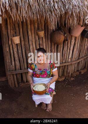 Valladolid, Yucatan/Mexiko - Februar 26,2020: Maya-Frau in ihrem traditionellen Huipilkleid, die eine Schale hält und ihre handgemachten Tortillas vor sich hält Stockfoto