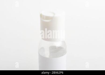 Ein Nahaufnahme der oberen weißen Kappe einer durchsichtigen Plastikflasche für Desinfektionsmittel im Taschenformat auf einem weißen Hintergrund. Stockfoto