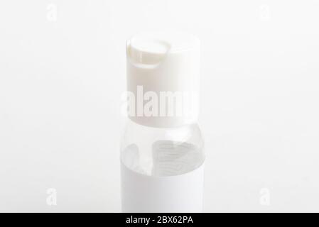 Ein Nahaufnahme der oberen weißen Kappe einer durchsichtigen Plastikflasche für Desinfektionsmittel im Taschenformat auf einem weißen Hintergrund. Stockfoto