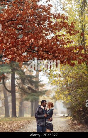 Glücklich interracial paar posiert im Herbst Park, schwarzer Mann und weiß rothaarige Frau Stockfoto