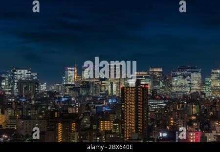 tokio, japan - märz 25 2020: Luftaufnahme der Gebäude und Wolkenkratzer Tokyos mit dem im Hintergrund beleuchteten Tokyo-Turm. Stockfoto