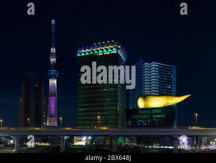 tokio, japan - märz 25 2020: Nachtansicht des beleuchteten Tokyo Skytree Turms und der goldenen flammenförmigen Skulptur des Asahi Beer Headquarter, wo ein Stockfoto