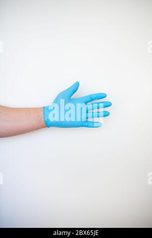 Hand in einem blauen medizinischen Einweg-Handschuh. Platz für eine Inschrift, Nahaufnahme. Stockfoto
