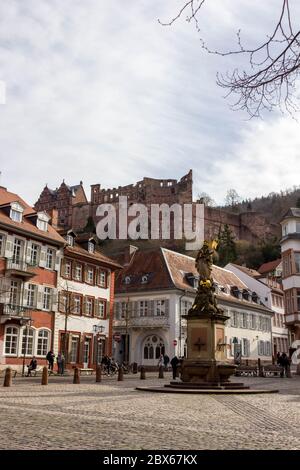 Malerisches historisches Gebäude in der Altstadt der Universitätsstadt Heidelberg, Deutschland mit schöner Burgruine im Hintergrund und Peststatue Stockfoto