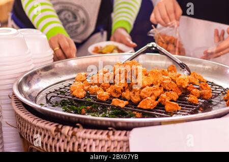 Tod Mun Kala, thailändische Küche mit Gurke und süßer saurer Sauce mit knusprig gebratenen heiligen Basilikumblättern. Stockfoto