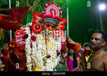 Die rituelle Kunst Form von Kerala, Thyra oder Theyyam thira ist ein ritueller Tanz, der in 'Kaavu'(Hain)& Tempeln des Kerala, Indien, aufgeführt wird Stockfoto