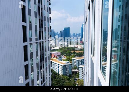 Blick von der oberen Etage auf die Straßen von Bangkok. Hohe Gebäude und Dächer von kleinen Häusern. Stadtlandschaft. Stockfoto