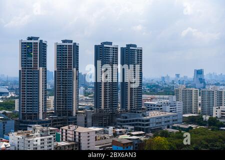 Blick von der oberen Etage auf die Straßen von Bangkok. Hohe Gebäude und Dächer von kleinen Häusern. Stadtlandschaft. Stockfoto