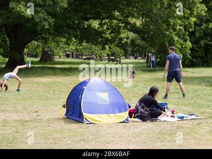 Familie genießt Sonnenschein in Greenwich Park an sonnigen Tag während covid-19 Pandemie für ein-Tag-Übung Richtlinie in England, Großbritannien Stockfoto