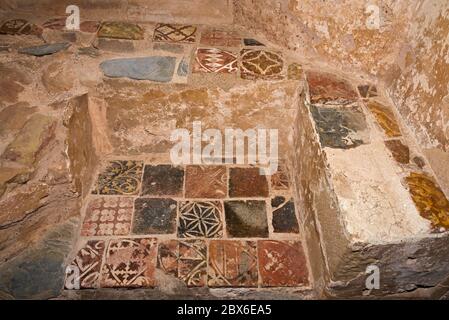 Dekorative geflieste Sitze im Schlafsaal von Cleeve Abbey, Washford, Somerset, England, Großbritannien. Ein denkmalgeschütztes Hotel, das von English Heritage geführt wird Stockfoto