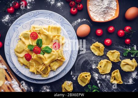 Italienische Pasta mit Zutaten und schwarzem Hintergrund. Gastronomisches Konzept Stockfoto