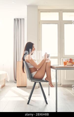 Slim schöne junge Frau genießen gesundes Frühstück am Morgen Stockfoto