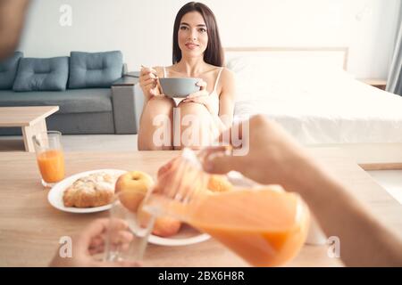 Fröhlich junge Brünette mit Frühstück mit ihrem boyfreind Stockfoto