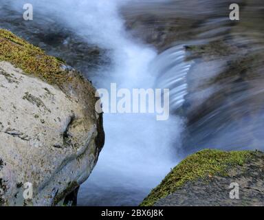 Wasser fließt über die Felsen Stockfoto