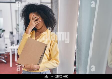 Erschöpft Mitarbeiterin stehend mit geschlossenen Augen Stockfoto