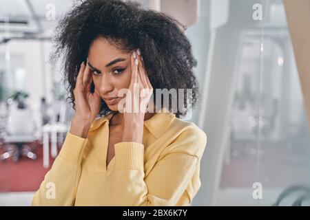 Ein junger Büroangestellter, der unter Kopfschmerzen leidet Stockfoto