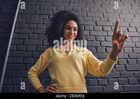 Zufrieden hübsche Dame stand gegen die Wand Stockfoto