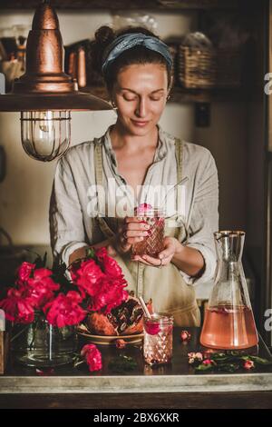 Junge Frau, die ein Glas Rose hausgemachte Limonade in den Händen hält Stockfoto