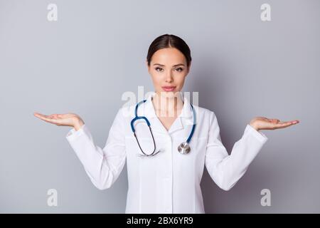 Foto von attraktiven doc professionelle halten zwei offene Handflächen leeren Raum Beratung gute Qualität Vitamine wählen Sie eine bessere tragen medizinische Uniform Labor Stockfoto