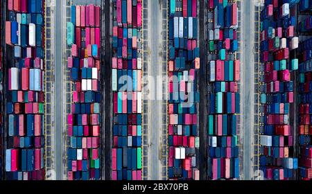 Draufsicht auf die bunten Container, die im Container Terminal/Port aufgefüllt sind und ein abstrahierendes Muster erzeugen Stockfoto