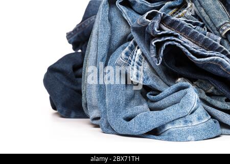 Stapel von verschiedenen Schattierungen von blauen Jeans auf weißem Hintergrund Stockfoto